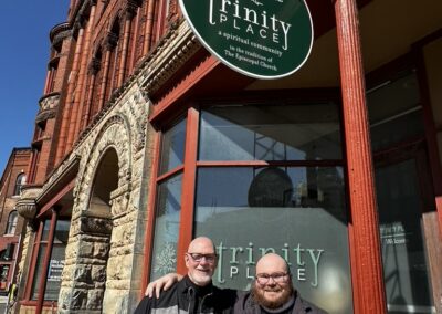 Two guests standing outside under the Trinity Place sign