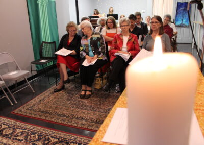 Congregation seated near a lit altar candle