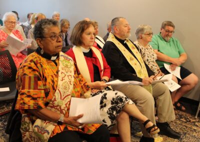 Clergy in colorful stoles seated with the congregation