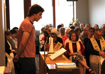 A young man standing to read at the lectern
