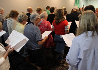 Congregation standing and singing from their programs