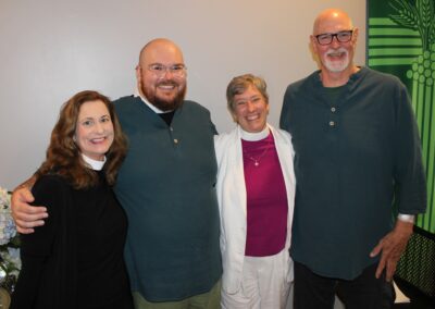 Four guests posing together, smiling